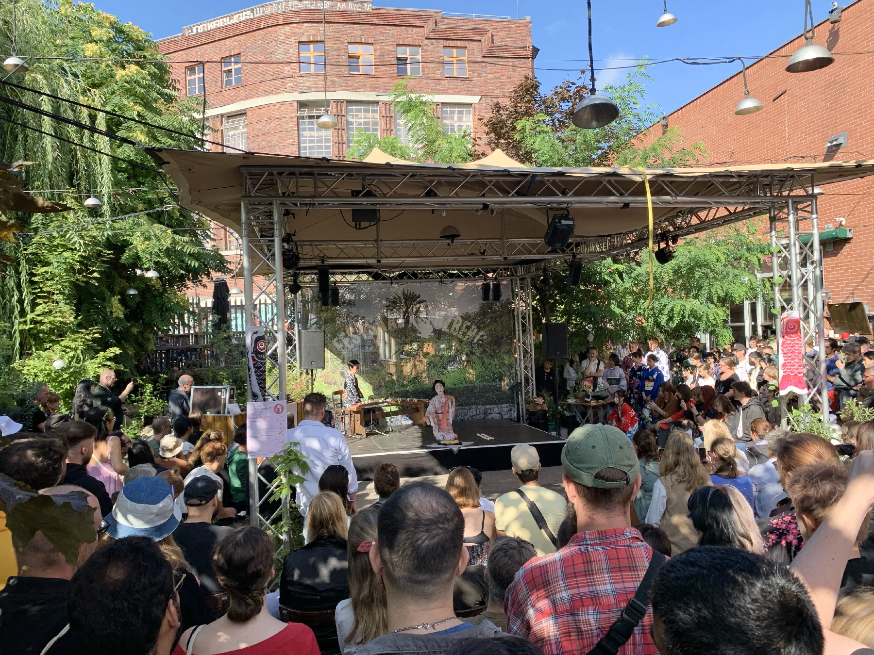 A stage with a packed audience showing a Japanese themed performance