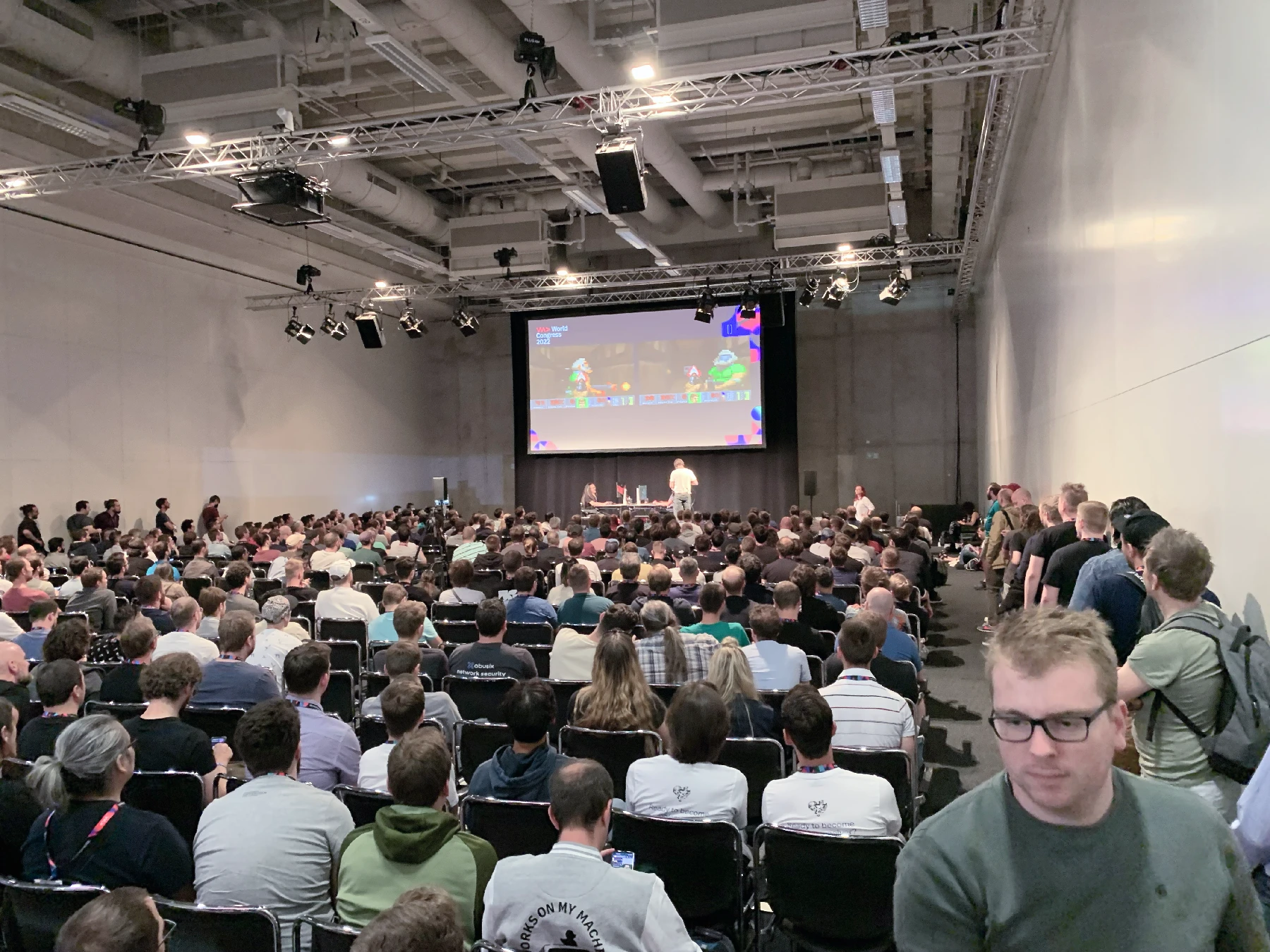 A large conference room with two PCs running Doom II on stage.