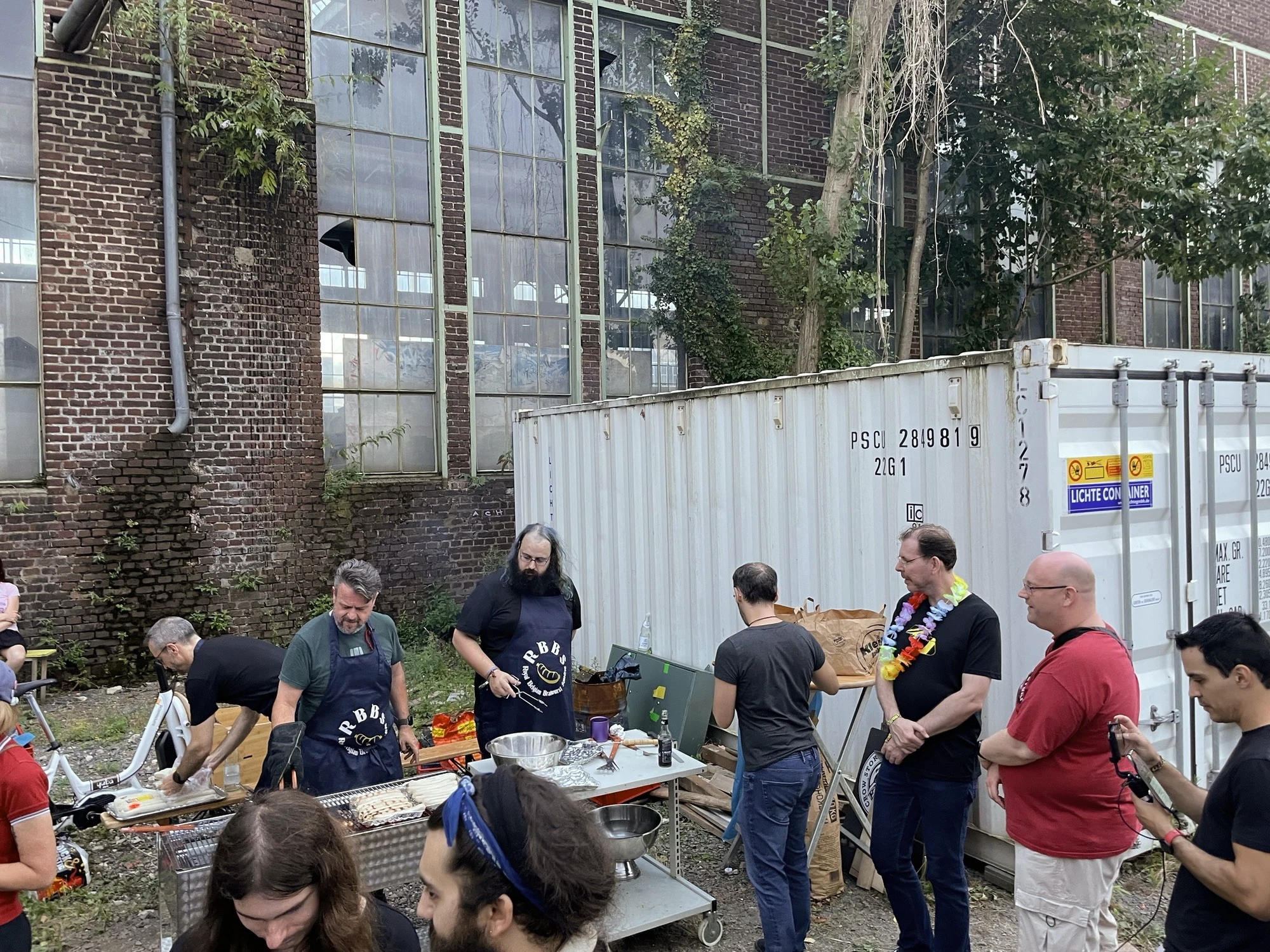 The line of people waiting for a sausage in a bread roll.