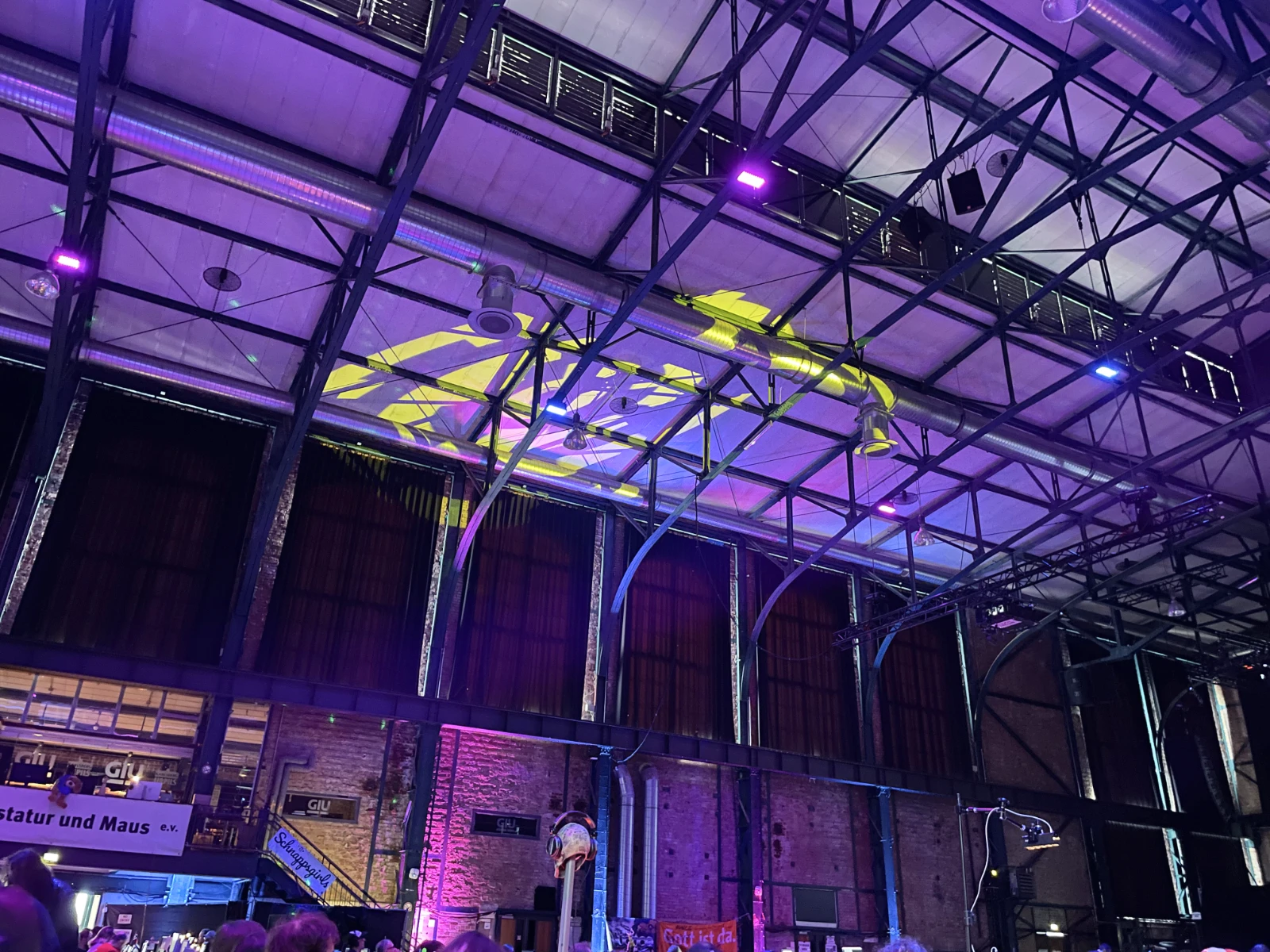 A large projection of the circular revision logo onto the steel-girdered ceiling of the main hall.